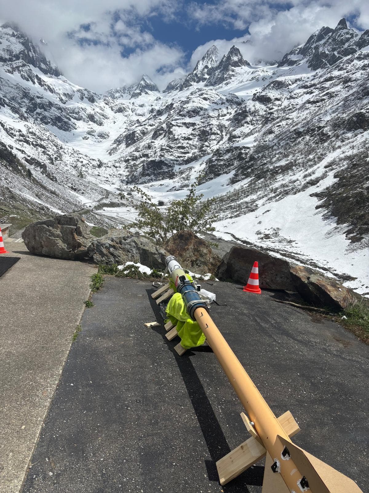 An ARIS rocket resting on its launch rail on a mountain road, snow-covered alpine valley behind it