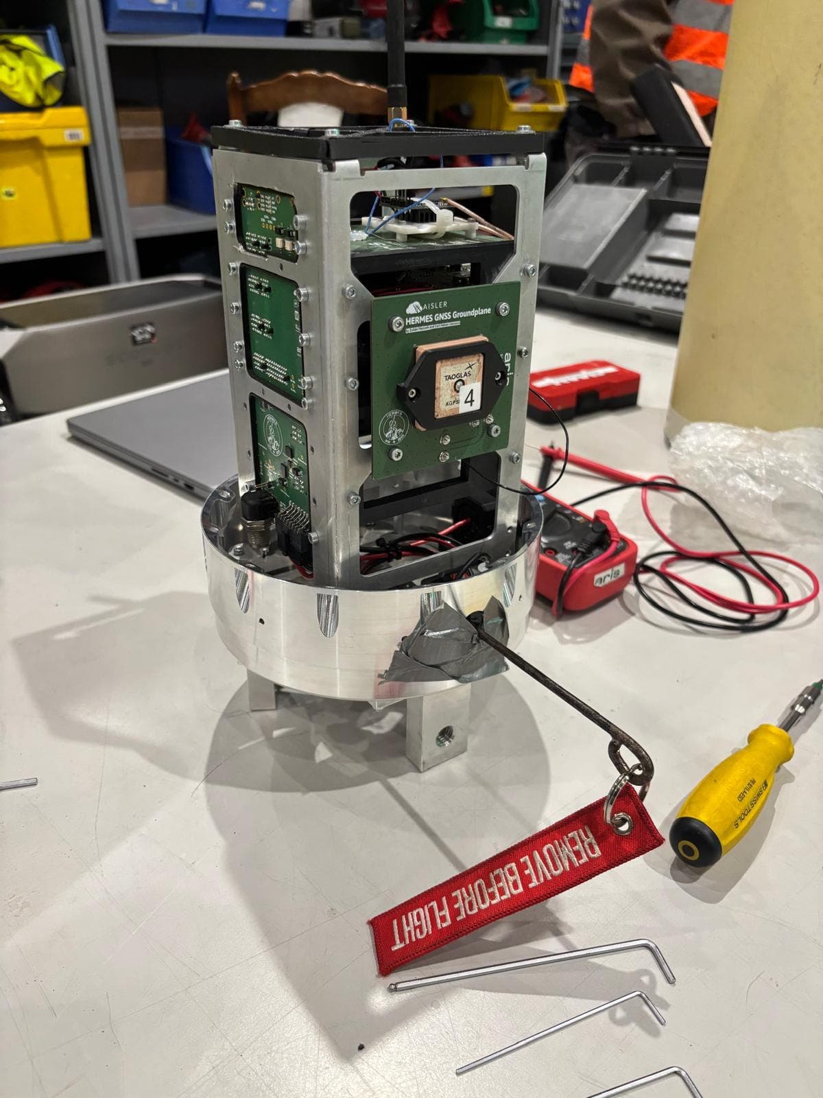 Avionics stack on the bench with a remove-before-flight tag