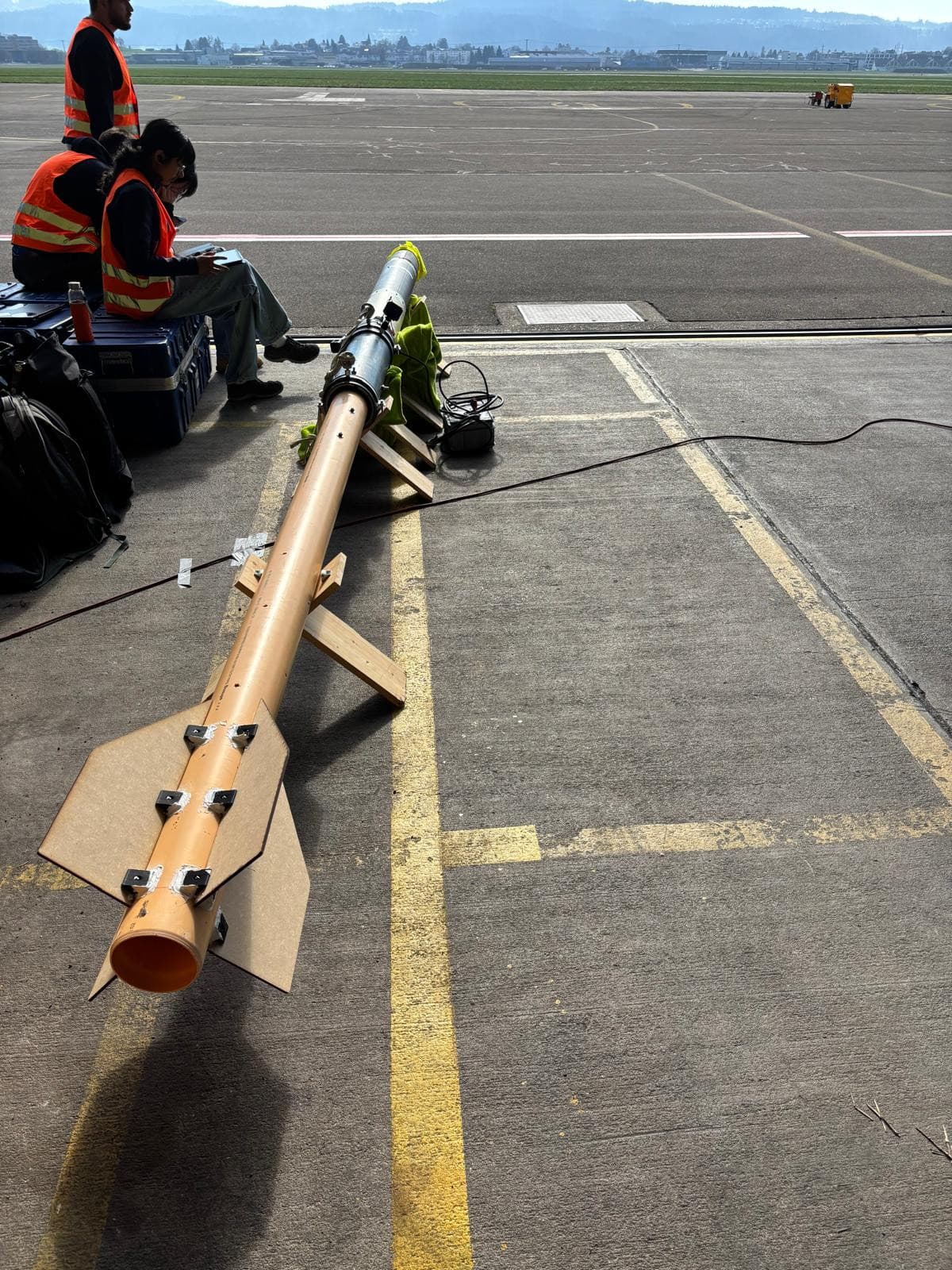 A rocket mounted on its launch rail on the tarmac, seen along the length of the rail before a test