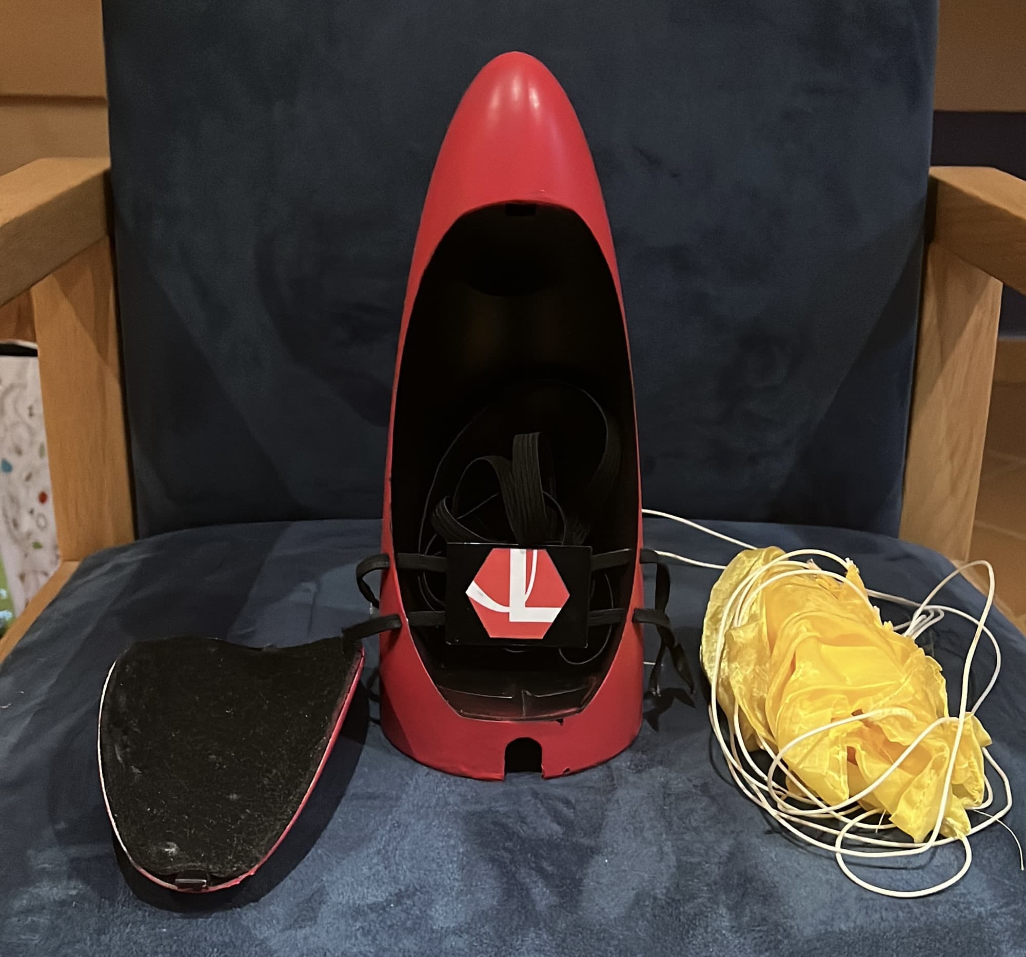 The red nose cone with its chamber open, the released door plate beside it and the yellow parachute unpacked
